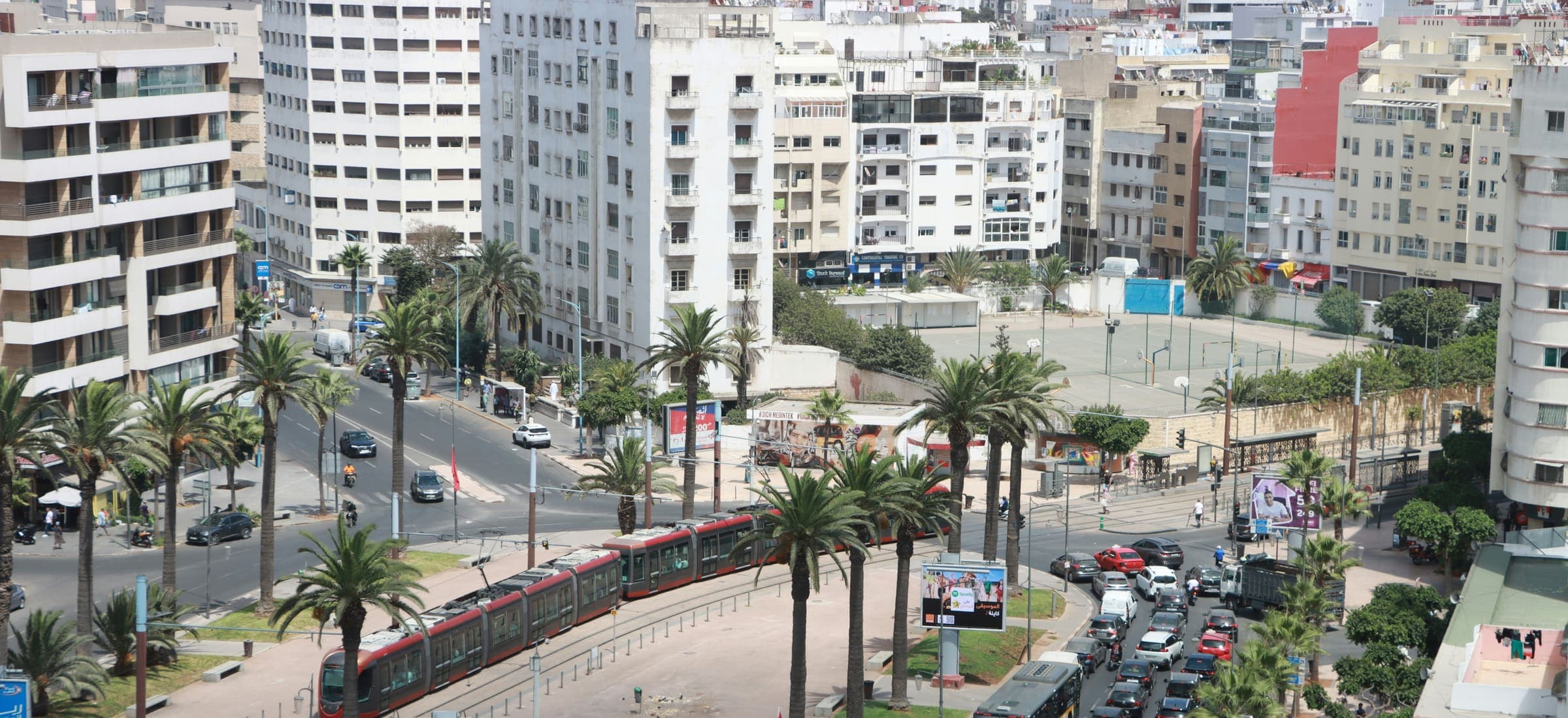 Vue plongeante sur un boulevard de Casablanca : le tramway, les palmiers du terre-plein et la circulation.